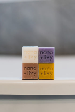 Nana + Livy soap blocks in rice milk, lavender, rose, and lemon stacked together without packaging