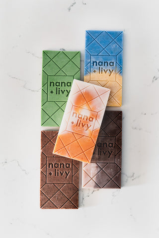 Five colourful choco soap bars on a counter without packaging