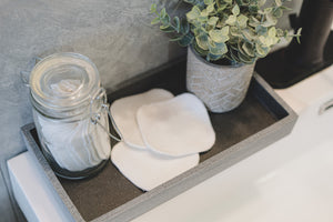 Decorative tray with white organic bamboo facial rounds on bathroom vanity