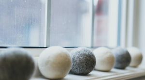 Alternating grey and white wool dryer balls on window sill
