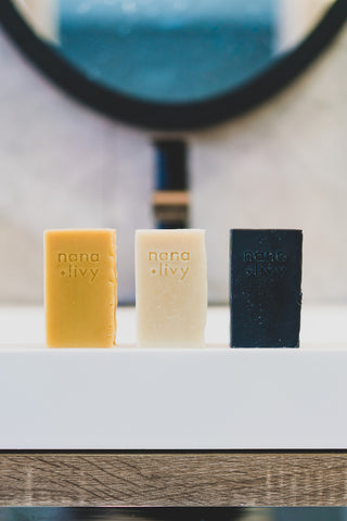 Nana + Livy row of three shampoo bars in ginger, rosemary and charcoal on vanity without packaging