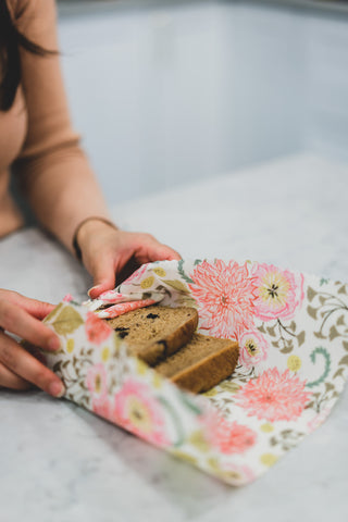 Woman wrapping sliced raisin bread in beeswax food wrap