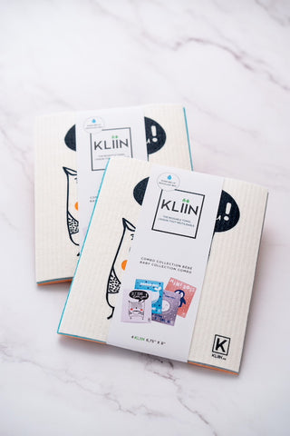 Two sets of Kliin reusable towels with kids prints displayed on marble surface. 