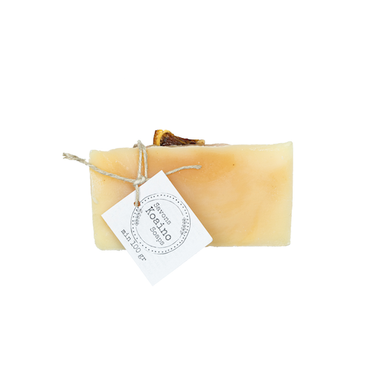 A single bar of citrus cream soap - an ivory coloured bar of soap with a dried orange slice on top, wrapped with twine and displaying a Koaino Soaps logo.
